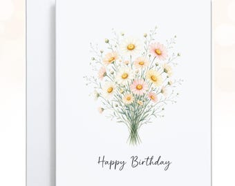 May include: A white greeting card featuring a watercolor illustration of a bouquet of daisies in shades of white, yellow, and soft pink. The text Happy Birthday is printed in a black script font centered below the floral arrangement.