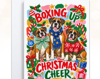 May include: A rectangular greeting card featuring three Boxer dogs surrounded by Christmas decorations and gifts. The dogs wear a green bow, a blue star-patterned scarf, and a red snowflake sweater. The text reads BOXING UP CHRISTMAS CHEER.