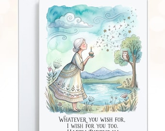 May include: A greeting card featuring a watercolor illustration of a person with gray hair blowing on a cupcake with a single candle. The scene includes a lake, mountains, an owl in a tree, and the text: Whatever you wish for, I wish for you too. Happy Birthday.