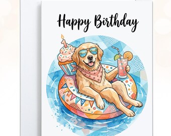 May include: A white greeting card featuring a golden retriever wearing sunglasses and a star-patterned bandana, floating on a colorful pool ring. The dog holds a pink drink, and a cupcake with a candle sits nearby. The text Happy Birthday is printed above.