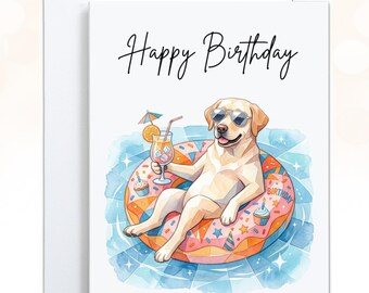 May include: A white greeting card featuring a yellow Labrador retriever wearing sunglasses, lounging in a pink donut-shaped pool float in blue water. The dog holds a cocktail with an umbrella. The text Happy Birthday is printed in black.