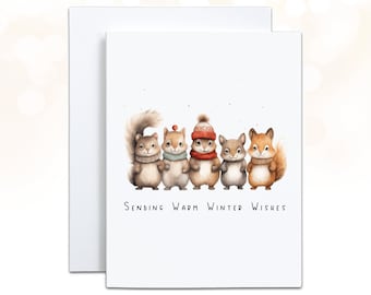 May include: A white greeting card with an illustration of five cartoon squirrels wearing scarves and hats. The text "Sending Warm Winter Wishes" is written below the squirrels. The card is paired with a white envelope.