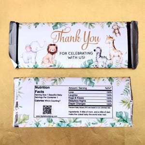 May include: A chocolate bar wrapper with a jungle theme. The front features an elephant, lion, zebra, and giraffe with the words "Thank You" and "For Celebrating With Us!". The back has nutrition facts and a QR code.
