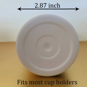 May include: A white tumbler base with a diameter of 7.29 cm. The base has a circular design and the text "Fits most cup holders". The tumbler is designed to fit in most standard cup holders.