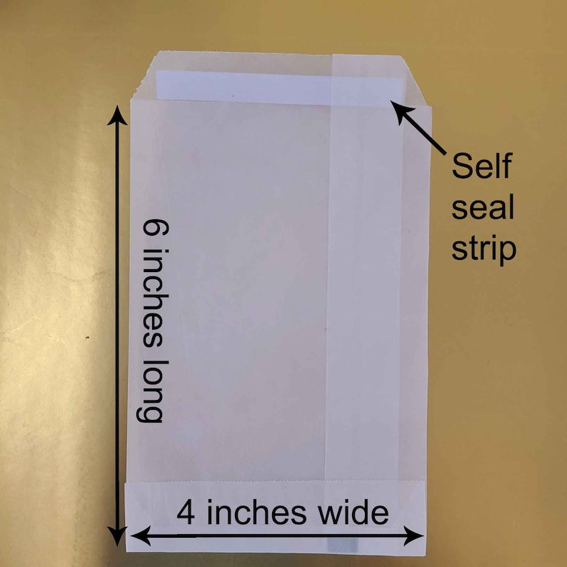 K&ouml;nnte beinhalten: Ein wei&szlig;er Selbstklebebriefumschlag mit einem selbstklebenden Streifen auf der oberen Klappe. Der Umschlag ist 15,24 cm lang und 10,16 cm breit.