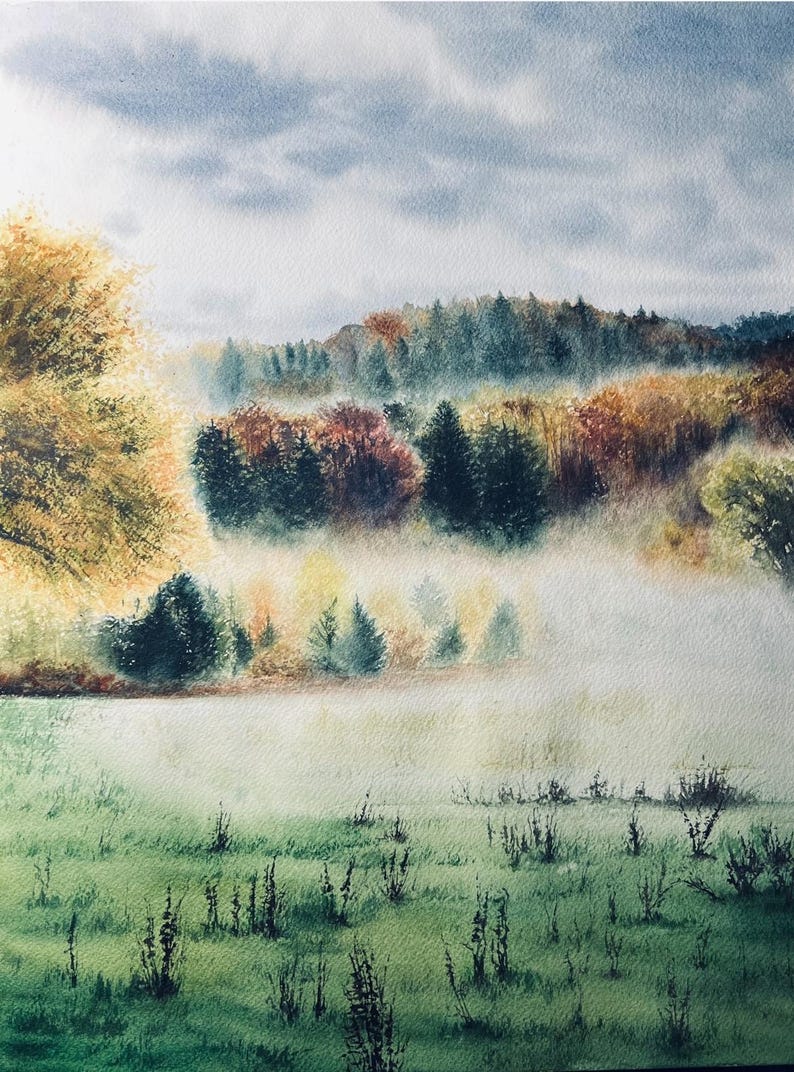 May include: Watercolor painting of a misty landscape. The artwork depicts a field of green grass in the foreground, with trees and a forest in the background. The sky is a light blue with some clouds. The colors are soft and muted.