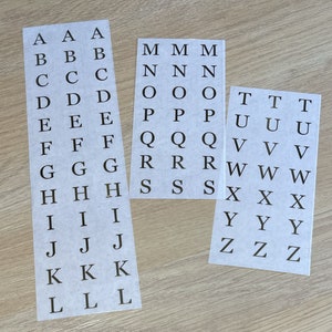 May include: Three sheets of white paper with black letters printed on them. The letters are in alphabetical order, starting with A and ending with Z. Each letter is repeated three times on each sheet.