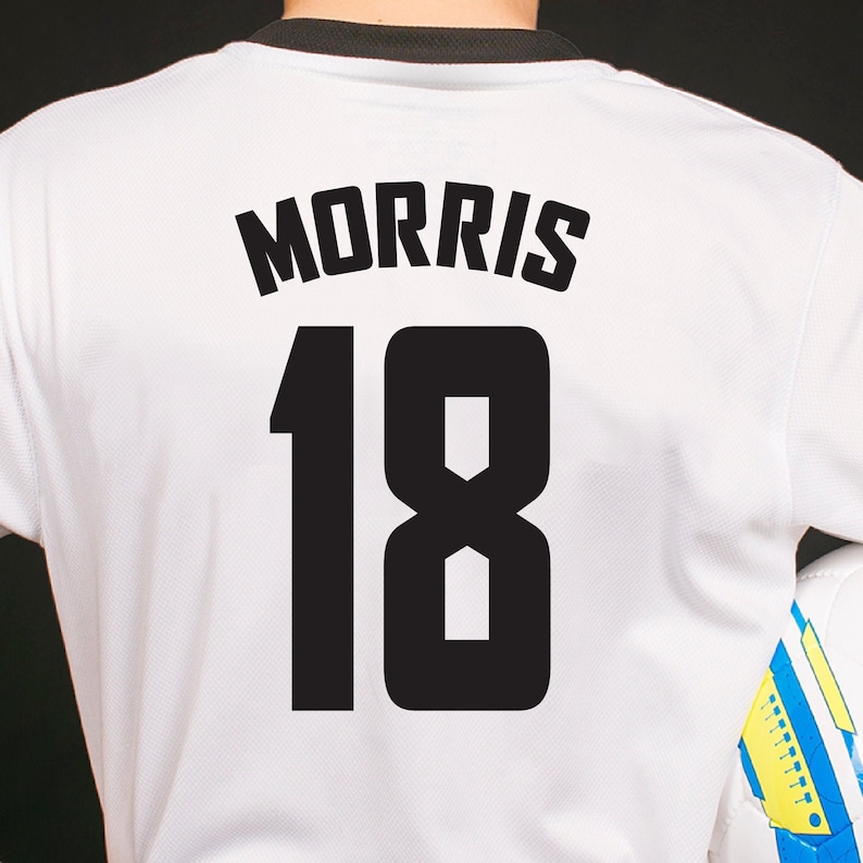 White soccer jersey with black text and numbers. The text reads "MORRIS" and the number is "18".