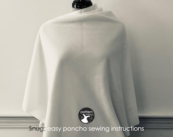 May include: A white poncho with a simple design. The poncho is draped over a mannequin and has a logo that says "pattern division" with a stylised bird design.