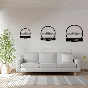 Puede incluir: Tres piezas de arte mural de metal negro con el texto "SIZE INFORMATION" dentro de un c&iacute;rculo. Los tama&ntilde;os son 43 cm x 43 cm, 66 cm x 66 cm y 79 cm x 79 cm. El arte se exhibe sobre un sof&aacute; gris en un sal&oacute;n moderno.
