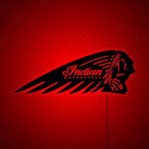 May include: Black Indian Motorcycle logo with red neon lighting. The logo features a stylized Native American headdress and the words "Indian MOTORCYCLE" in a script font. The image is set against a red background.