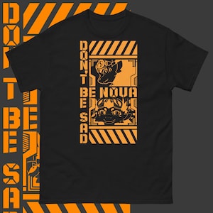 May include: Black t-shirt with an orange graphic design. The graphic features two cartoon characters with the text "DON'T BE SAD BE NOVA".