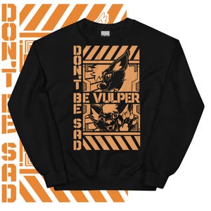 Puede incluir: Sudadera negra con un diseño gráfico naranja. El gráfico presenta dos zorros de dibujos animados con el texto "Don't Be Vulper Sad" en un fondo a rayas negro y naranja.