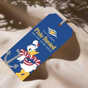 Op de afbeelding: Een rechthoekig blauw cadeaulabel met een wit touwtje, voorzien van een afbeelding van Donald Duck in een rood-wit gestreept shirt, een grijs anker en de tekst "YOU'VE BEEN PIXIE DUSTED ON THE HIGH SEAS" met een geel Mickey Mouse-logo.