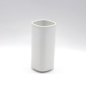 Puede incluir: Un florero cilíndrico alto de color blanco con un acabado liso y brillante y esquinas redondeadas. El recipiente presenta una parte superior ancha y abierta y una estructura sólida y opaca, mostrando una apariencia limpia y uniforme.