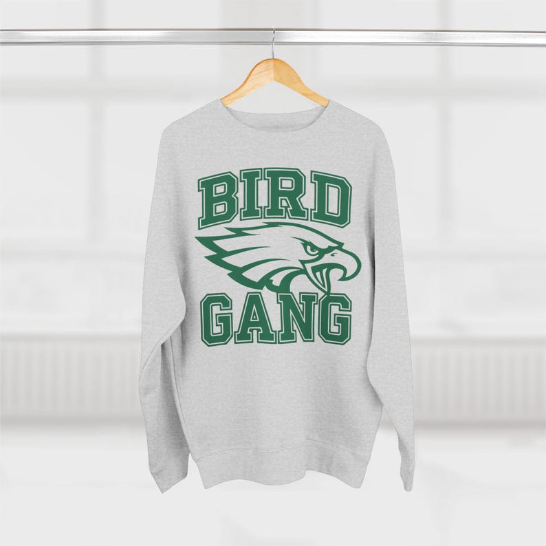 May include: A grey sweatshirt with a green eagle graphic and the text "BIRD GANG" in a collegiate font.