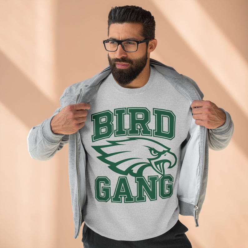 May include: A grey sweatshirt with a green eagle graphic and the text "BIRD GANG" in a collegiate font.