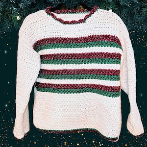 May include: A white crocheted sweater with green and burgundy stripes. The sweater has a scalloped neckline and hem.
