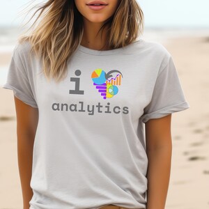 Puede incluir: Una camiseta gris con el texto "I ♥ analytics" y un gráfico colorido de gráficos y tablas en forma de corazón.