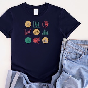 May include: A navy blue t-shirt featuring a graphic design of nine colourful data and analytics icons. The icons include a pie chart, bar graph, line graph, and more.