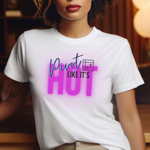 May include: White t-shirt with the text "Pivot Like It's Hot" in pink neon lettering. The text is accompanied by a black and white icon of a computer screen with an arrow pointing upwards.