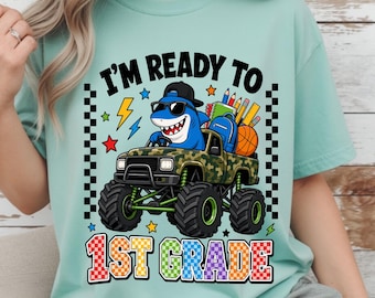 1年生モンスタートラックPNG、レトロな新学期昇華プリント、クールなサメが運転するカモフラージュトラックTシャツデザイン、キッズクラスパーカーグラフィックアート