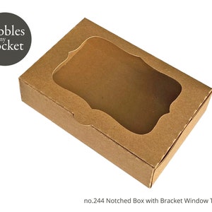 Puede incluir: Una caja de cartón marrón con una ventana transparente y un diseño con muescas. La caja tiene una plantilla de ventana con soporte. El texto "no.244 Notched Box with Bracket Window Template" está impreso en la parte inferior de la caja.