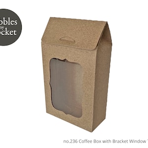 Puede incluir: Una caja de café de cartón marrón con una ventana transparente y un diseño de soporte. La caja tiene una solapa en la parte superior y el texto "Pebbles in my pocket" está impreso en la parte delantera.