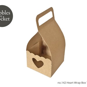 May include: A brown paper heart wrap box template with a handle. The box has a heart-shaped cutout on the front and scalloped edges. The text "pebbles in my pocket" is in a circle on the left.