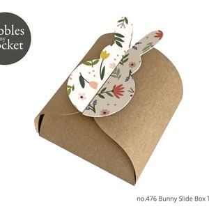 May include: A brown paper slide box with a floral bunny design. The box is labeled "no. 476 Bunny Slide Box Template".