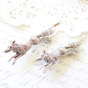 May include: Two silver fox hair clips, each featuring a detailed fox design in a running pose. The clips are perfect for adding a touch of whimsy to any hairstyle.