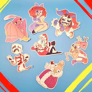 Op de afbeelding: Een verzameling van zeven cartoonkarakterstickers met een verscheidenheid aan ontwerpen. De stickers tonen karakters in tinten roze, rood, paars en bruin, met witte contouren. De achtergrond is lichtblauw met gele en rode verfstreken.