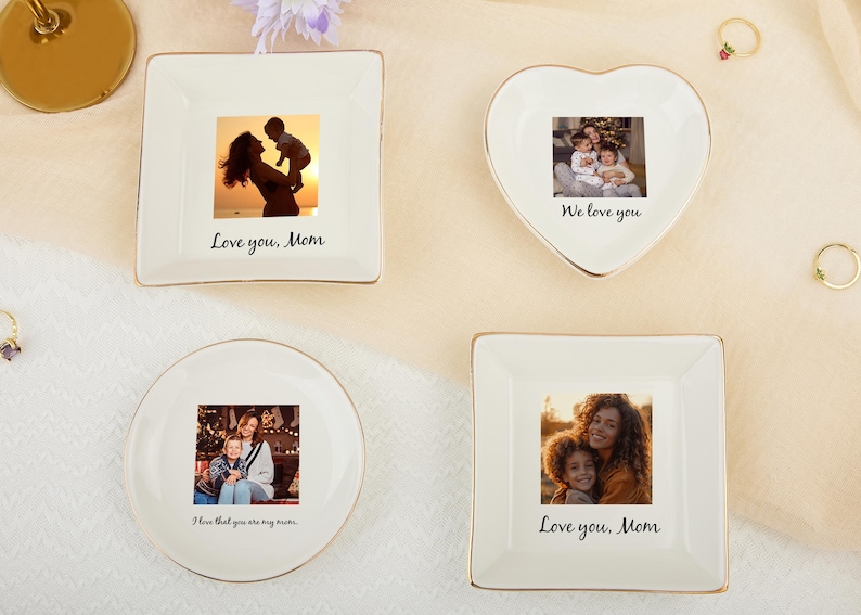 May include: Four white ceramic trinket dishes with gold trim, each featuring a family photo. One is heart-shaped, others are square and round. Text includes "Love you, Mom" and "We love you."