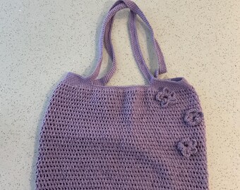 Knitted purple tote bag with flowers attached