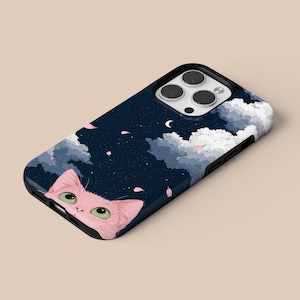 May include: A navy blue phone case featuring a pink cat peeking out from the bottom. The case has a night sky design with white clouds, a crescent moon, and pink flower petals. The cat has green eyes.