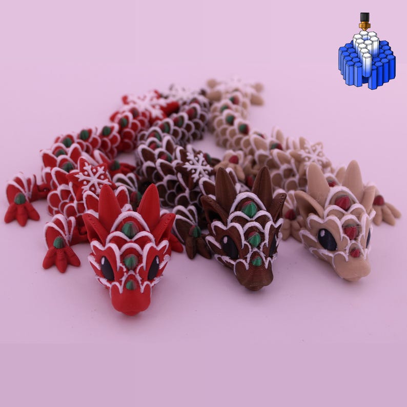 May include: Three articulated dragon figurines featuring a scale-like texture with snowflake patterns. The dragons are colored in red, dark brown, and light tan, each accented with white outlines and small green or red gems on their heads.