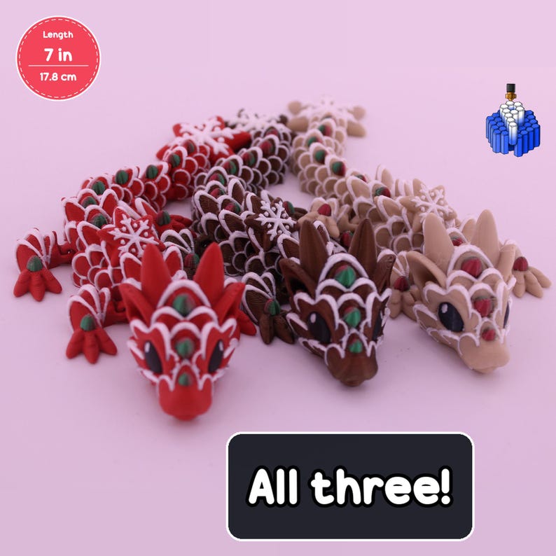 May include: Three articulated dragon figurines, each 7 inches long, featuring snowflake-patterned scales in red, dark brown, and light beige. Each dragon has white accents, green details, and large dark eyes. The text All three! is visible.