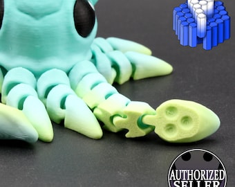 May include: A 3D printed articulated creature in a gradient of mint green to pale yellow, featuring large black eyes and segmented limbs. A small blue hexagonal icon appears in the top right, and a circular badge reads AUTHORIZED SELLER.