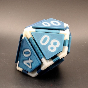 May include: A multi-sided die with blue and white triangular faces. The numbers 00, 08, and 40 are visible in white on the blue faces. The die is designed with a complex geometric structure.