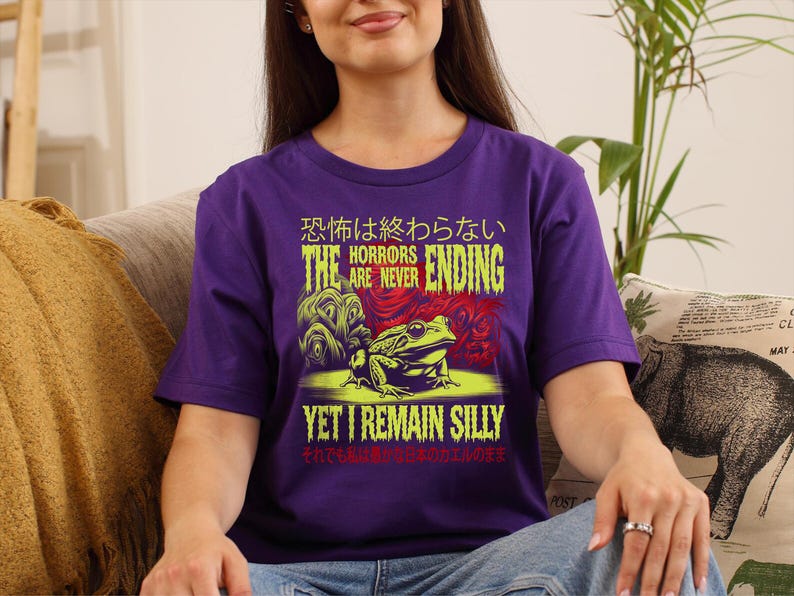 May include: Purple t-shirt featuring a green frog and the text "The horrors are never ending, yet I remain silly" in Japanese and English.