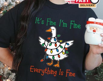 May include: Black t-shirt with a graphic of a white goose decorated with colorful Christmas lights. The text "It's Fine I'm Fine Everything Is Fine" is printed in green and red.