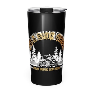 Puede incluir: Vaso de viaje negro con tapa plateada. El vaso presenta un gráfico con el texto "A SIDE CHIC" en letras doradas, un vehículo todoterreno blanco y la frase "I PLAY ROUGH AND DIRTY."
