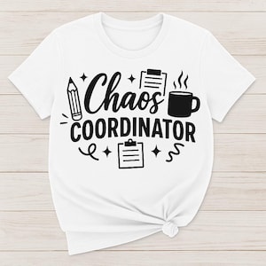 May include: White t-shirt with black text that reads "Chaos Coordinator" and includes a pencil, clipboard, and coffee cup graphic.