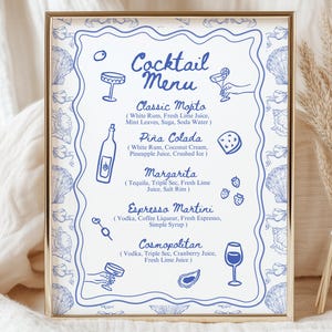 May include: A framed cocktail menu with a gold border. The menu has a blue and white design with illustrations of cocktail ingredients and glasses. The menu lists classic cocktails like Mojito, Piña Colada, Margarita, Espresso Martini, and Cosmopolitan.