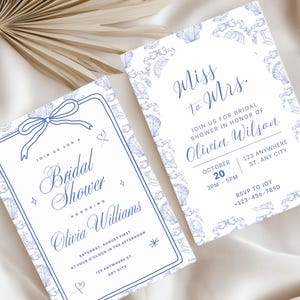 May include: Two white bridal shower invitations with blue text and decorative seashell borders. One invitation reads "Bridal Shower" and the other says "Miss to Mrs." with event details. A bow and hearts are also featured.