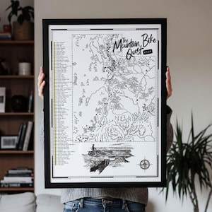 May include: A framed black and white map titled The Mountain Bike Quest Utah, featuring a detailed topographical illustration of trails, a numbered list of locations, a compass rose, and a graphic of a cyclist on a cliff edge.