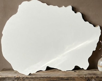 May include: A large, white, irregularly shaped mirror with a smooth, reflective surface and organic, wavy edges. The mirror is positioned horizontally, showcasing a clean, glossy finish that reflects light across its expansive, non-uniform form.