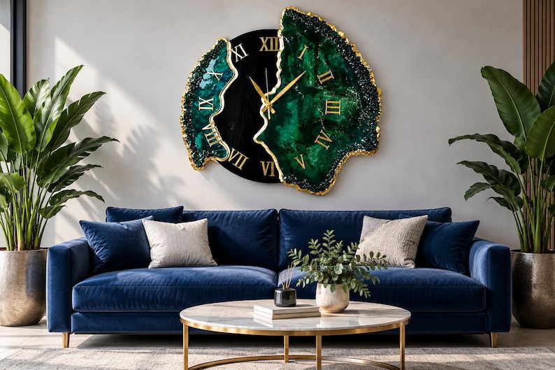 Puede incluir: Un reloj de pared con un centro circular negro y dos secciones irregulares de color verde esmeralda inspiradas en geodas, con bordes pintados en oro. La esfera muestra n&uacute;meros romanos dorados y finas manecillas doradas.