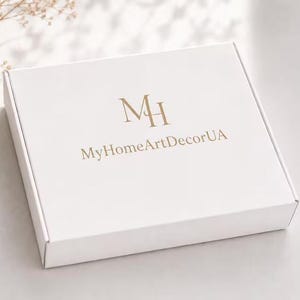 Puede incluir: Una caja de env&iacute;o rectangular de cart&oacute;n blanco con un logotipo de color dorado que muestra las letras MH y el texto MyHomeArtDecorUA impreso en el centro de la tapa. La caja tiene un acabado mate y un dise&ntilde;o de cierre plegable.