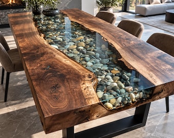 May include: A rectangular dining table featuring two thick, natural-edge dark wood slabs joined by a central transparent resin inlay filled with smooth, multi-colored river stones, supported by a sturdy black metal frame base.